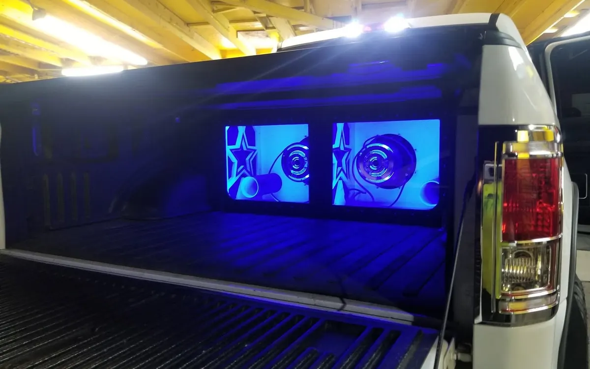 A truck bed build at Mr. Tint with twin screens and blue lighting behind the cab