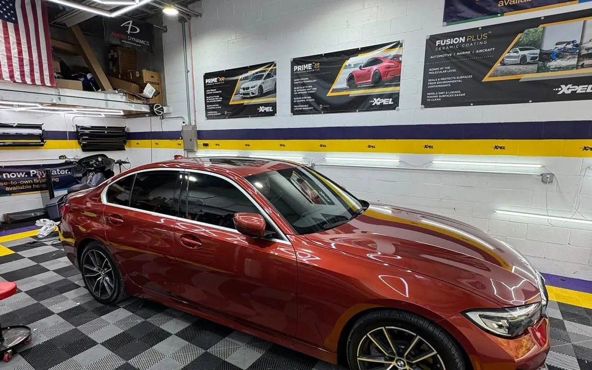 A red BMW saloon with tinted windows outside the Mr. Tint shop in Plum, Pennsylvania