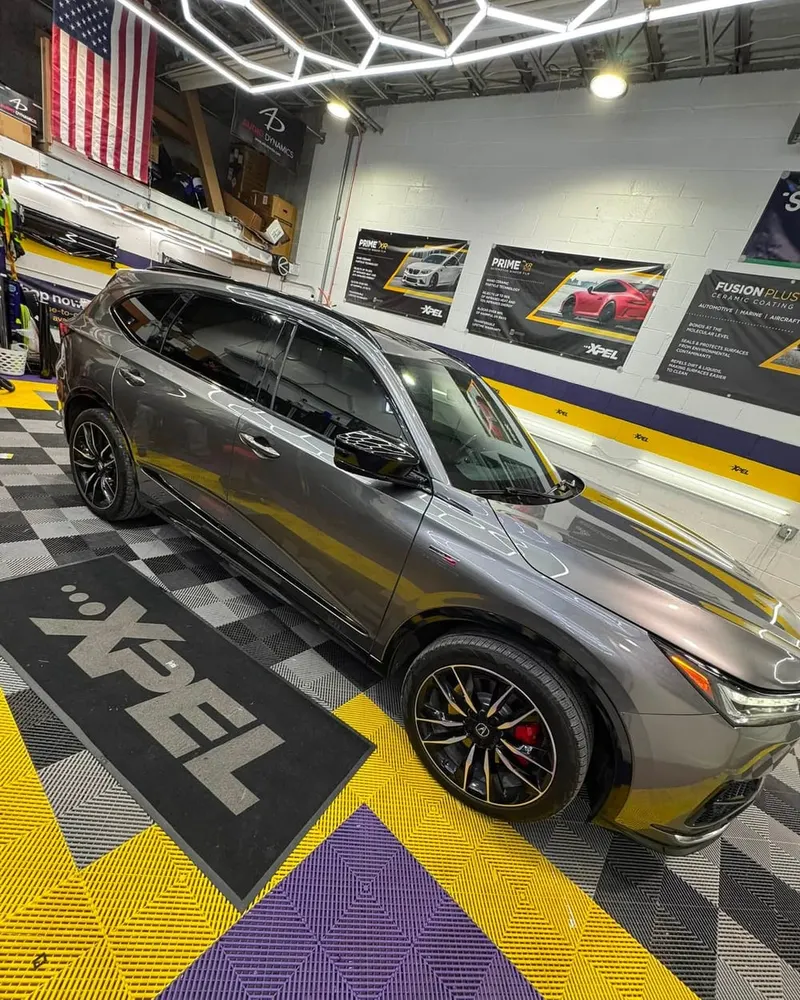 A ceramic-coated SUV under the hexagon lighting of the Mr. Tint bay
