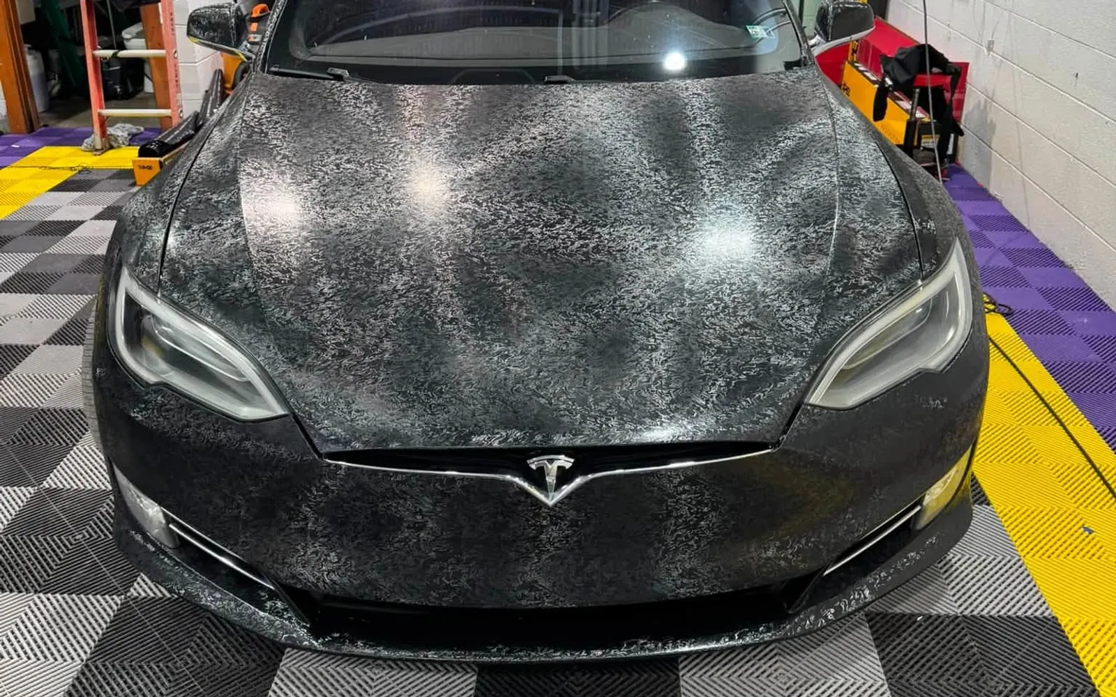 Water beading across the bonnet of a ceramic-coated saloon on the Mr. Tint shop floor