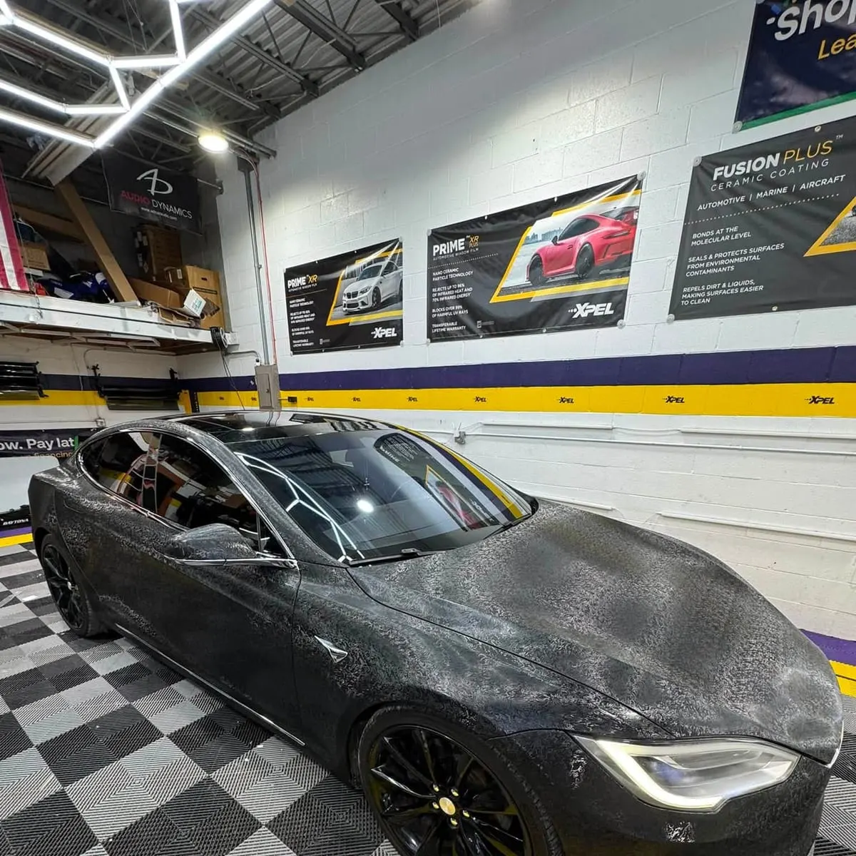 A ceramic-coated car in the Mr. Tint bay with water beading across every panel