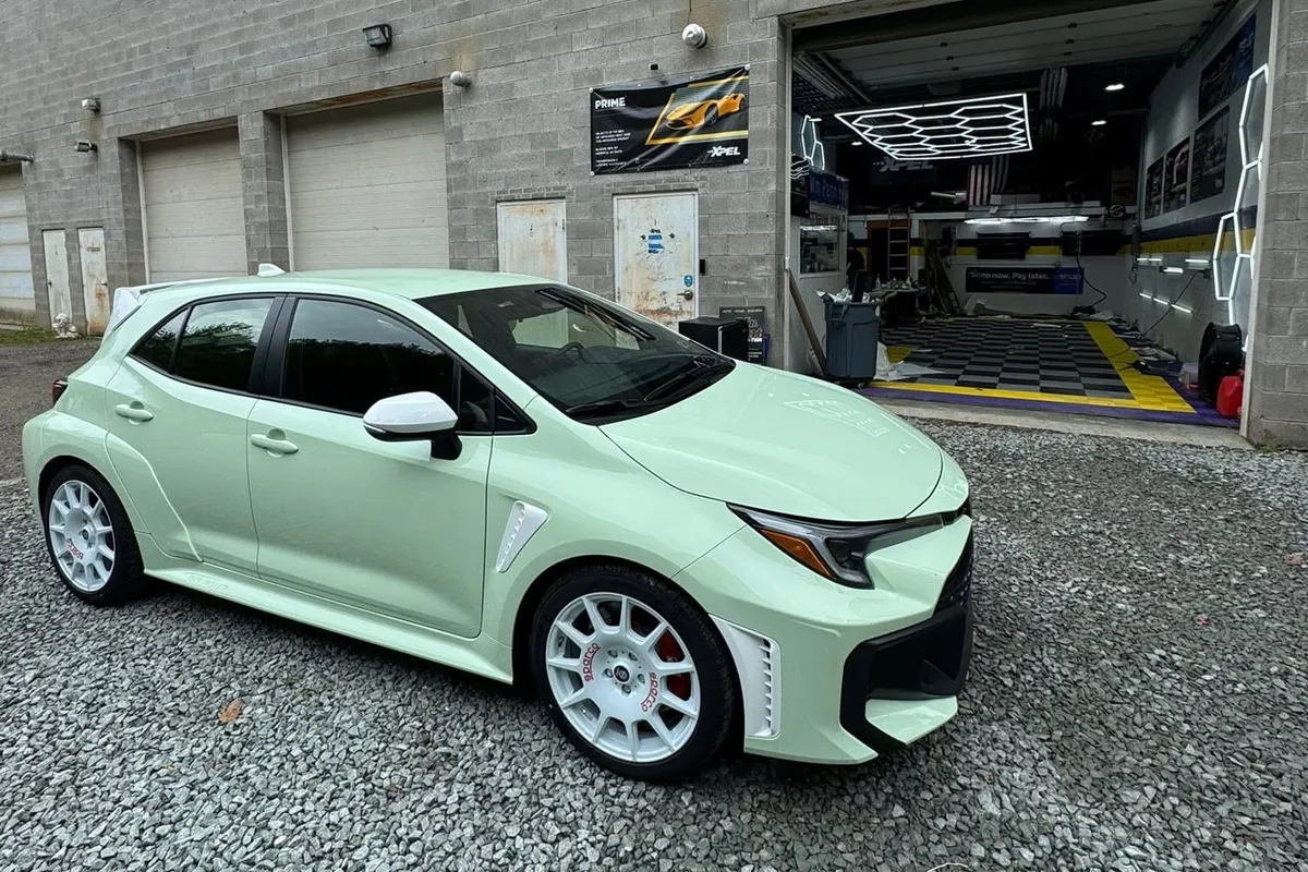 A mint green Toyota GR Corolla in the Mr. Tint installation bay after ceramic coating