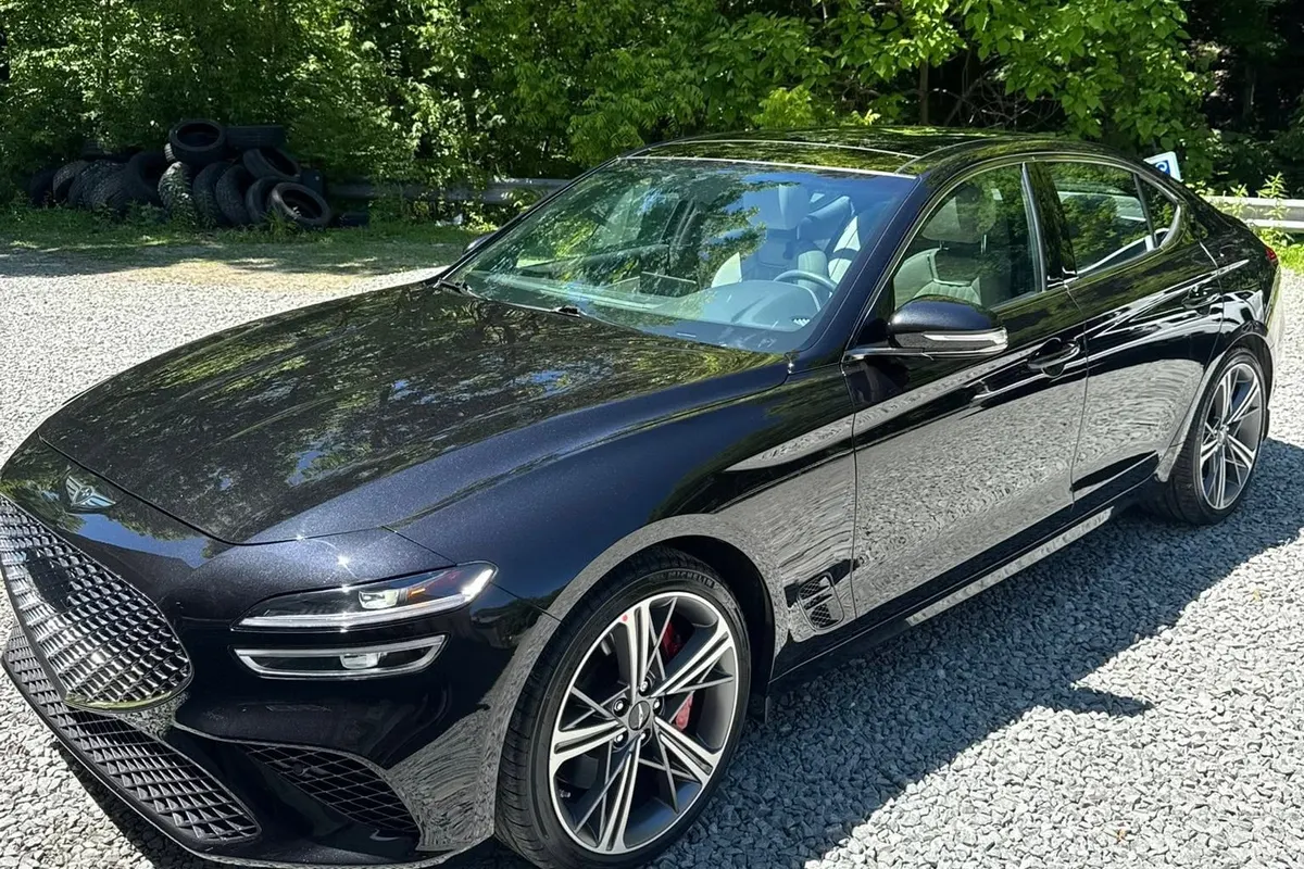 A navy saloon on the gravel lot at Mr. Tint after ceramic coating