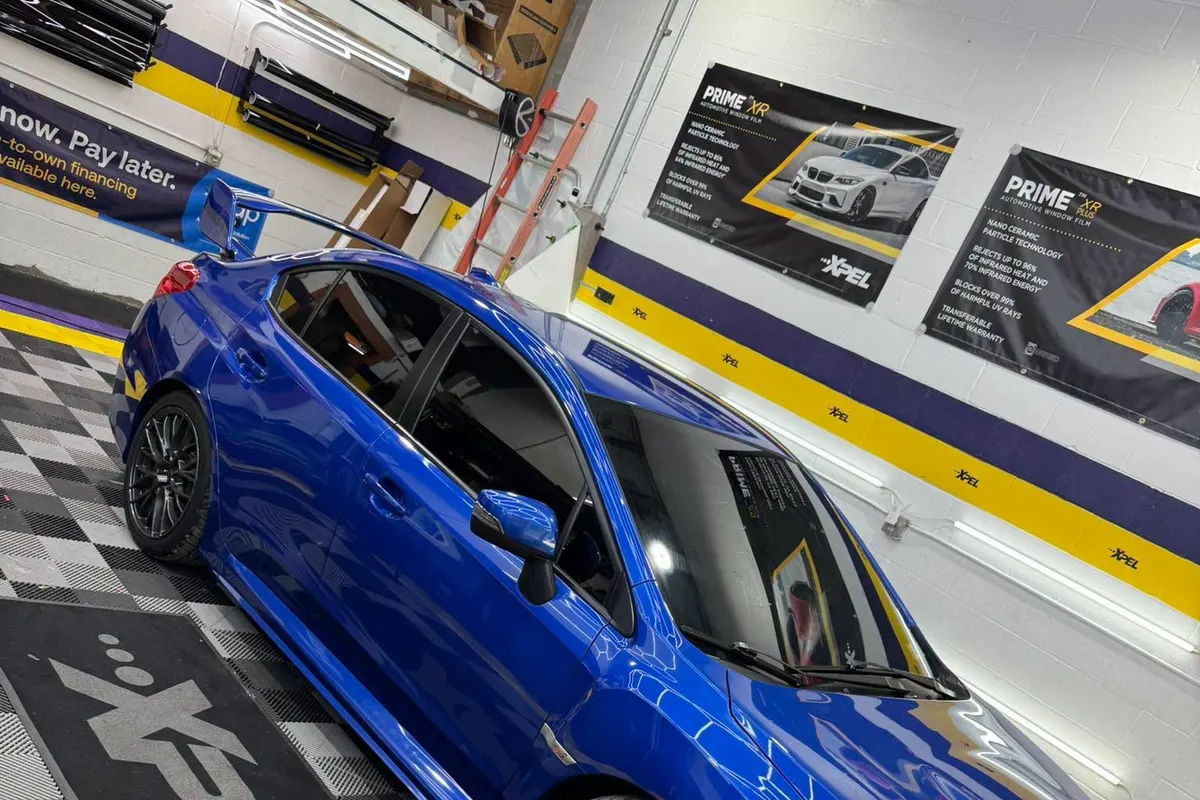 A blue Subaru WRX in the Mr. Tint installation bay after ceramic window tint