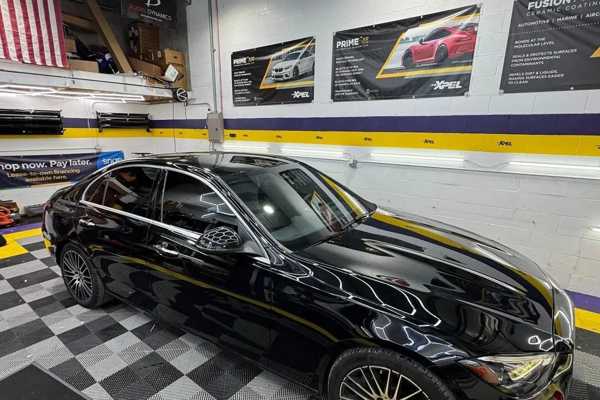 A black Mitsubishi Lancer Evolution on the checker floor of the Mr. Tint bay after ceramic window tint
