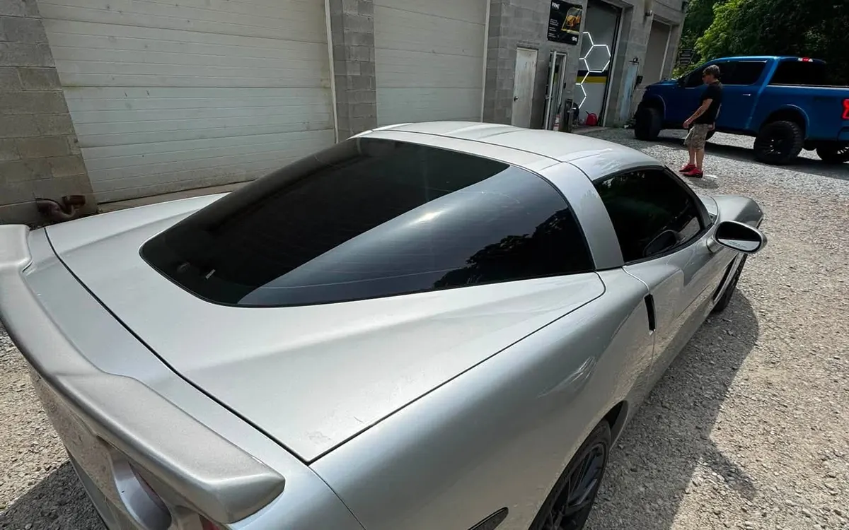 A silver Chevrolet Corvette with ceramic window tint, seen from the rear corner at Mr. Tint in Plum, Pennsylvania