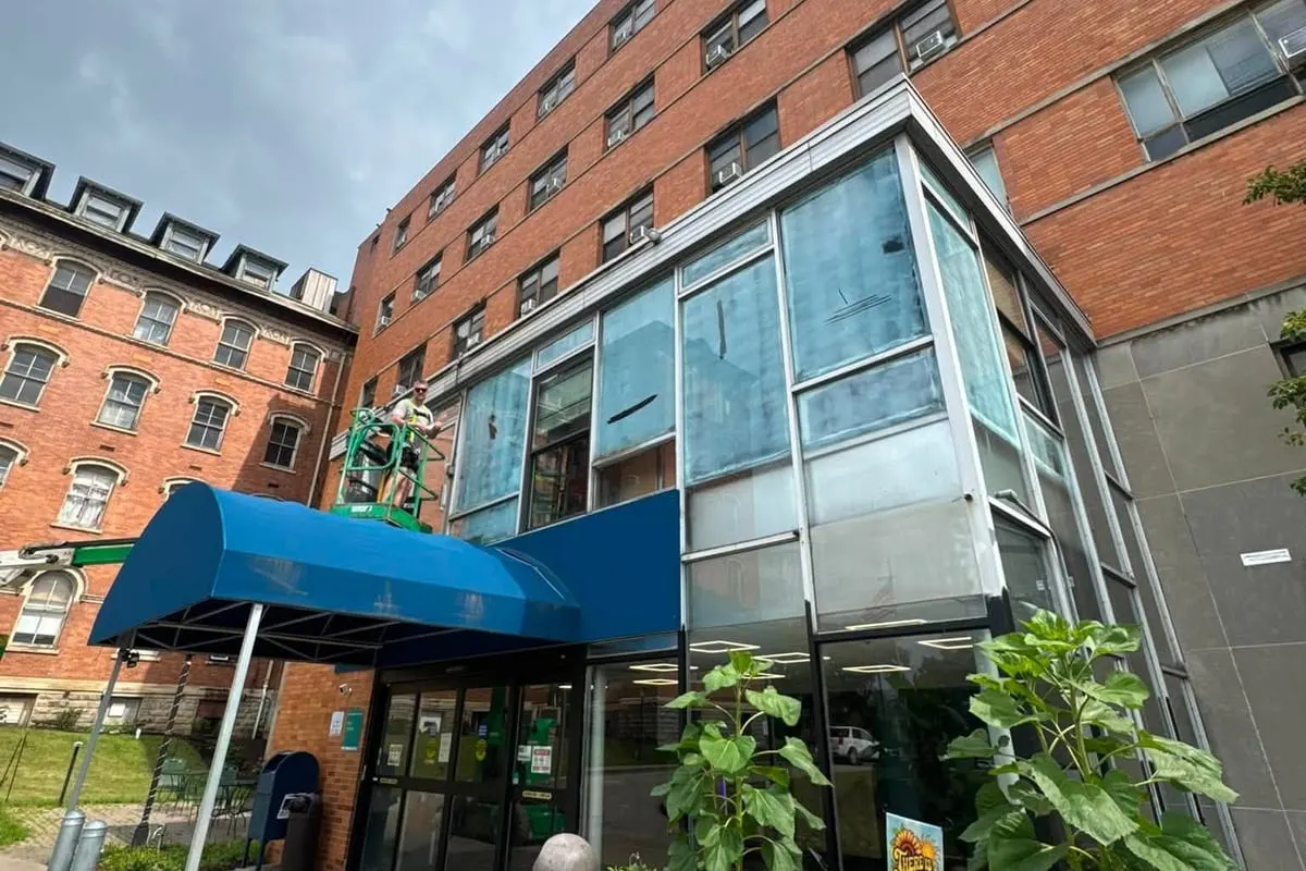 The filmed glass frontage and entrance of a Pittsburgh commercial building, seen from the pavement