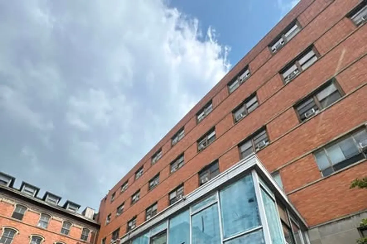 A brick commercial building in Pittsburgh with a glazed frontage and blue awning, fitted with solar control film