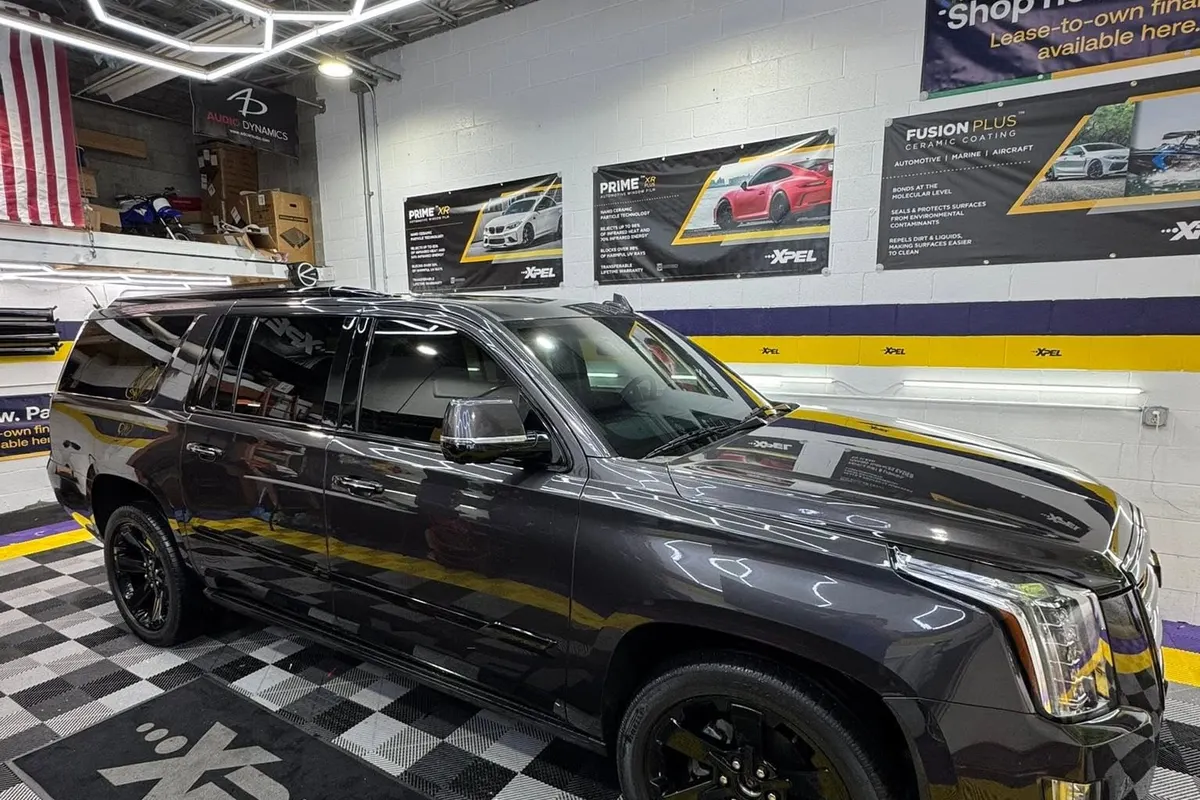 A black Cadillac Escalade on the XPEL mat in the Mr. Tint installation bay