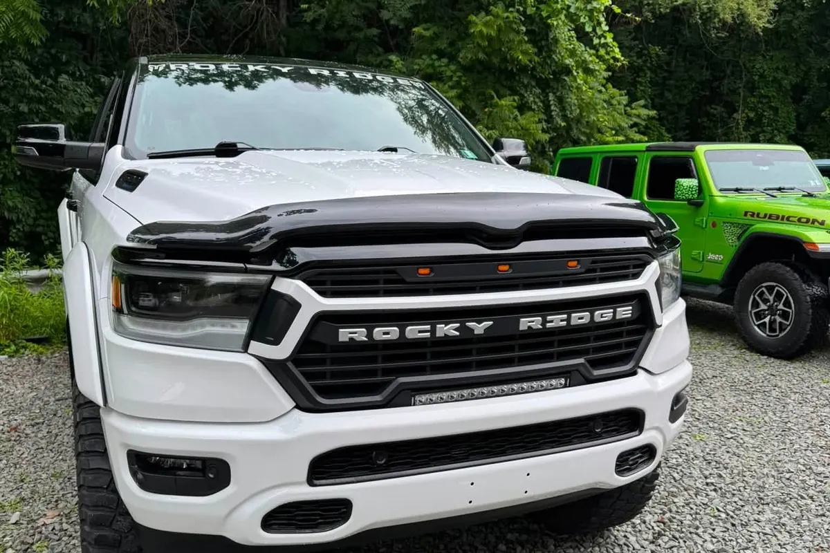 A white Ram 1500 pickup with paint protection film on the gravel at Mr. Tint