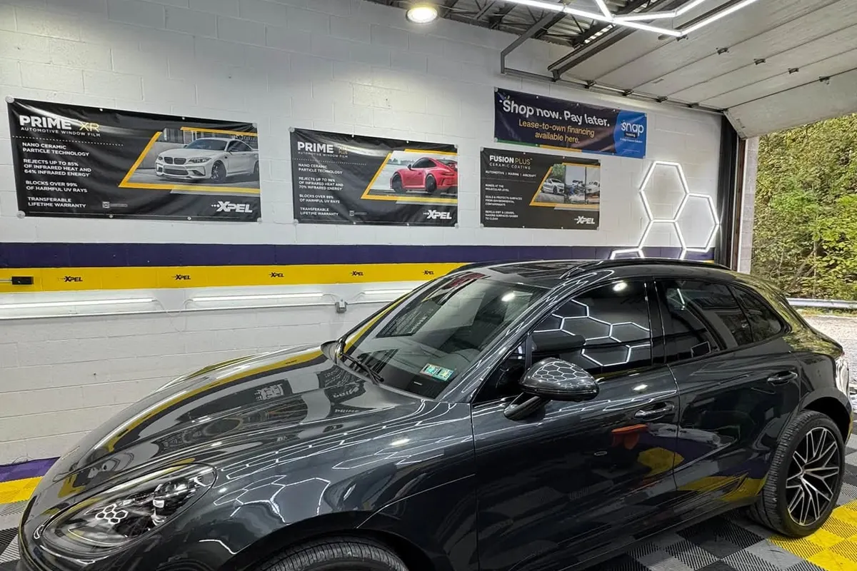 A black Porsche Macan in the Mr. Tint installation bay after window tinting