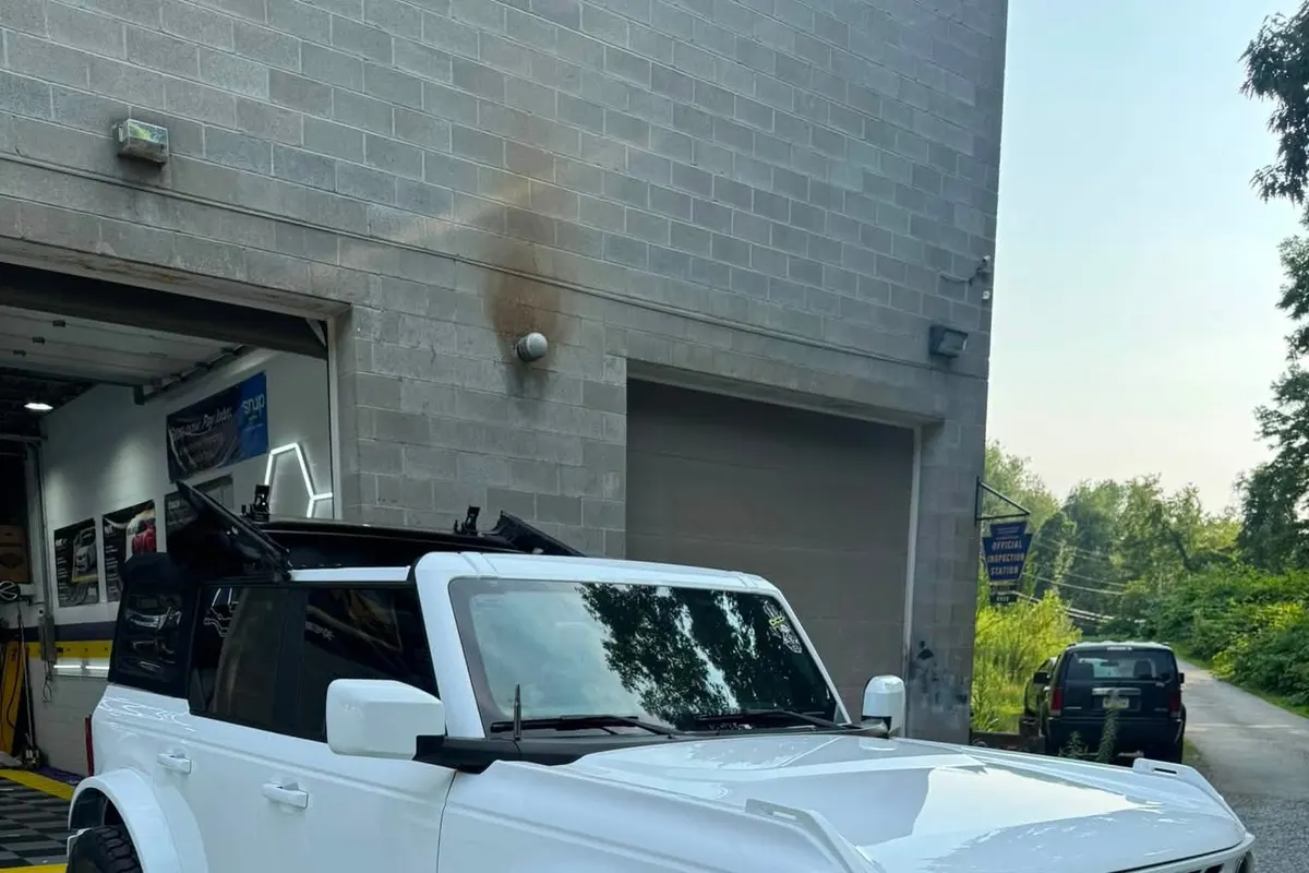 A white Ford Bronco seen from the front corner outside the Mr. Tint bay