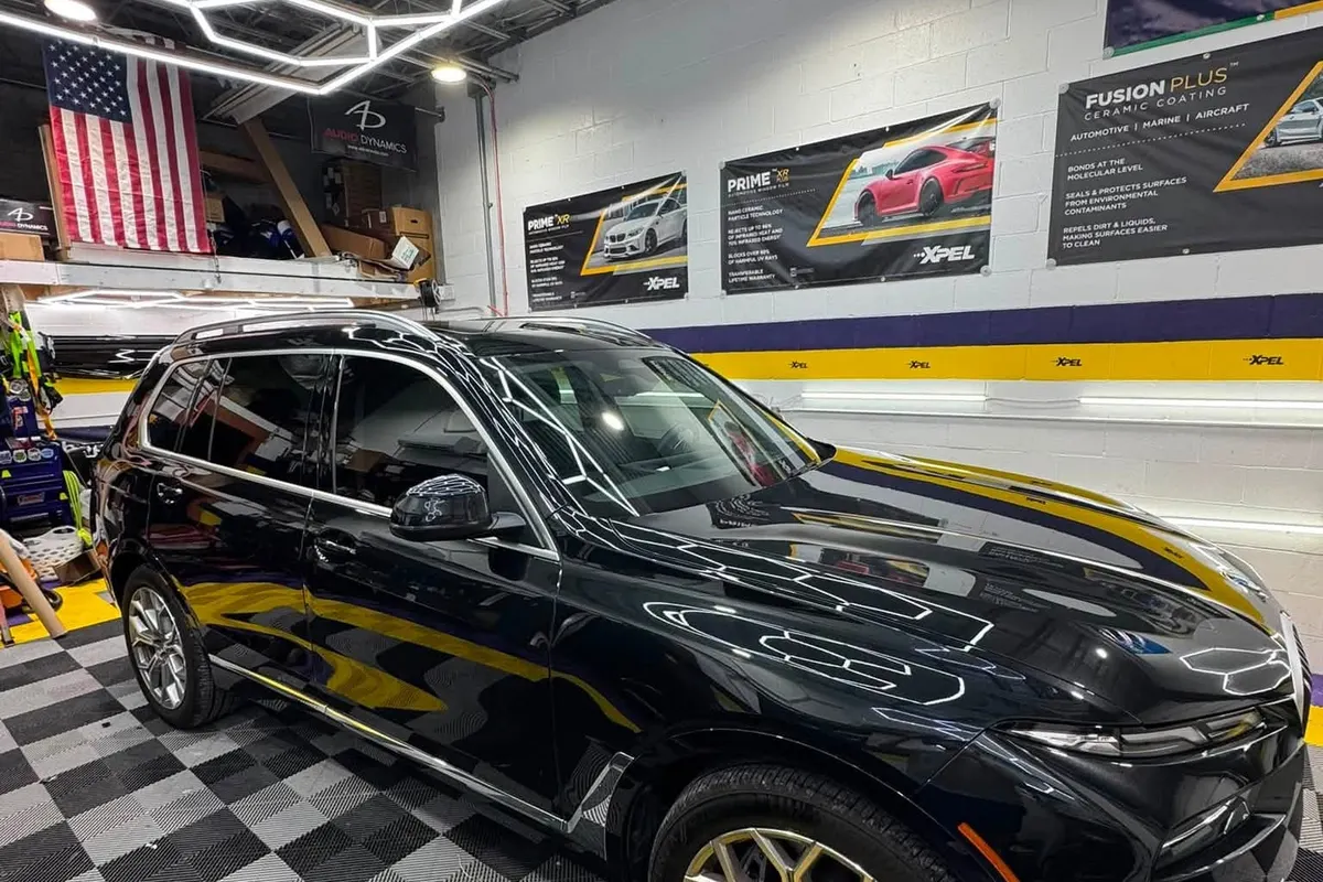 A black BMW X7 in the Mr. Tint bay under the hexagon lighting