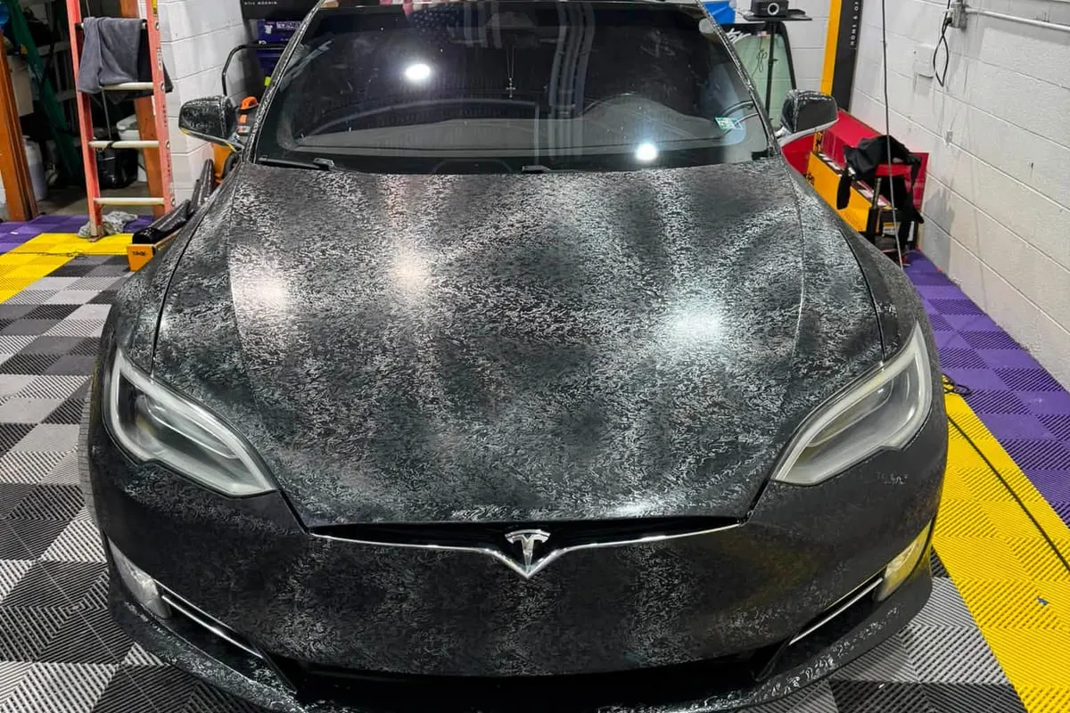 Water beading across the bonnet of a ceramic-coated Tesla at the Mr. Tint shop