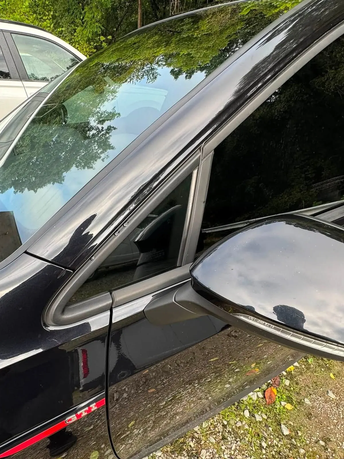 Dark window film on the front door glass and windscreen of a black car finished at Mr. Tint