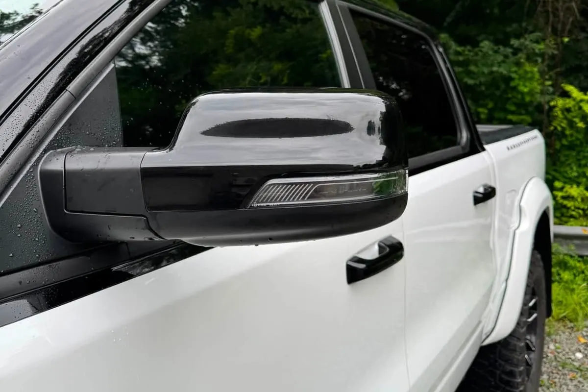 Paint protection film along the door edge and wing mirror of a white pickup