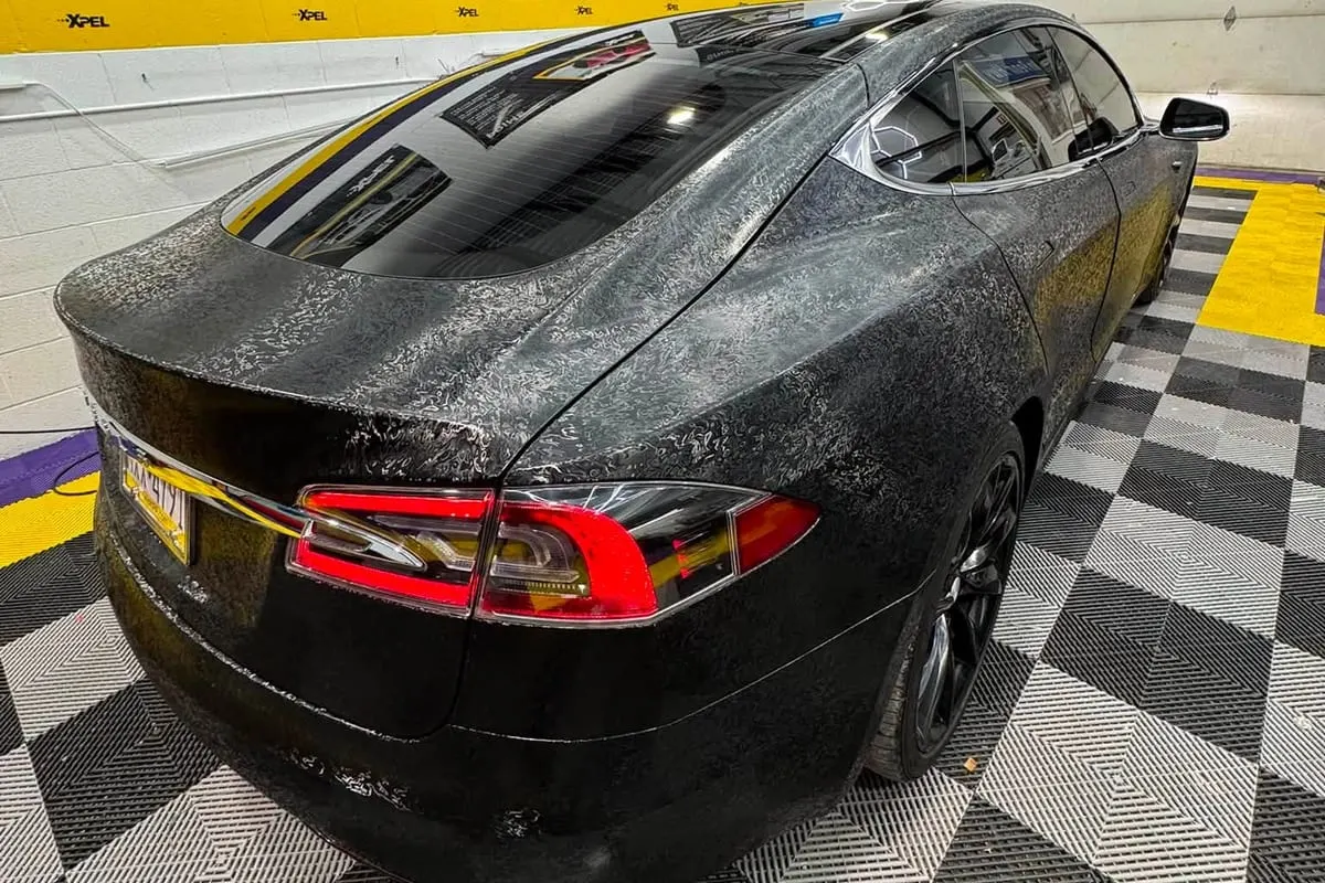 Water beading across the rear bodywork of a ceramic-coated Tesla on the Mr. Tint shop floor