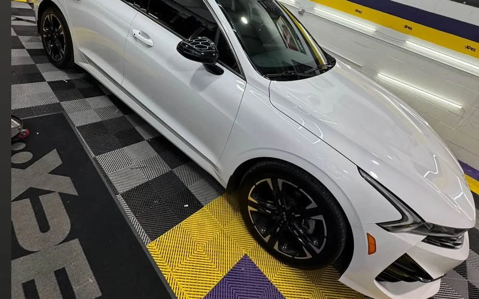 A white saloon on the XPEL-branded floor of the Mr. Tint installation bay in Plum, Pennsylvania