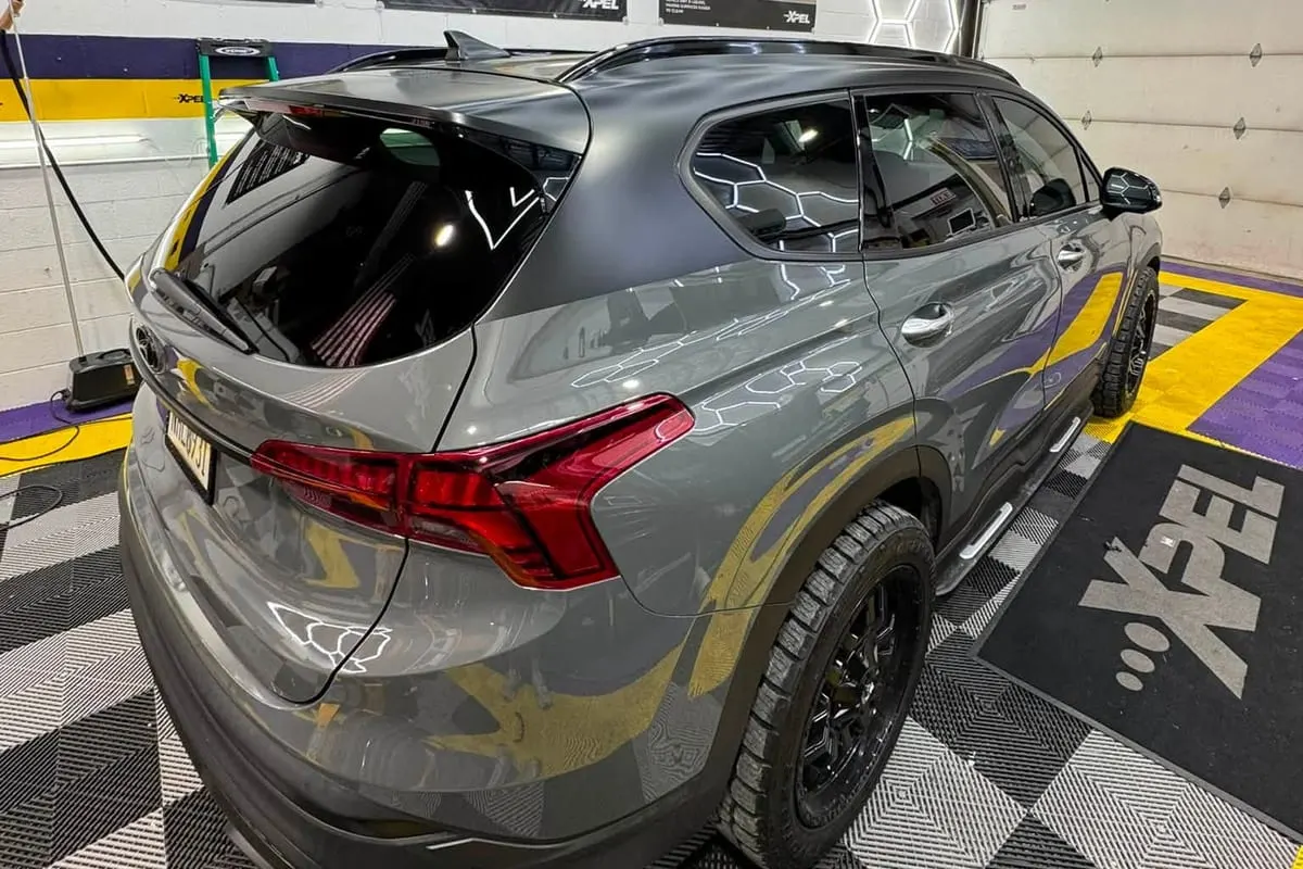 An SUV under the hexagon lighting of the Mr. Tint installation bay