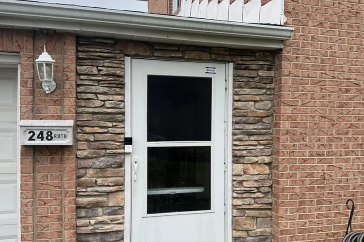 A house with a stone and brick frontage and a white glazed front door, in the Pittsburgh area