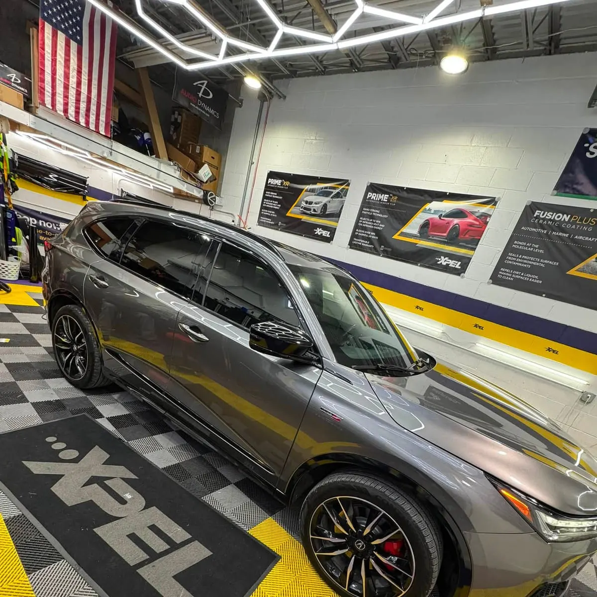 A tinted SUV under the hexagon lighting of the Mr. Tint installation bay in Plum, Pennsylvania
