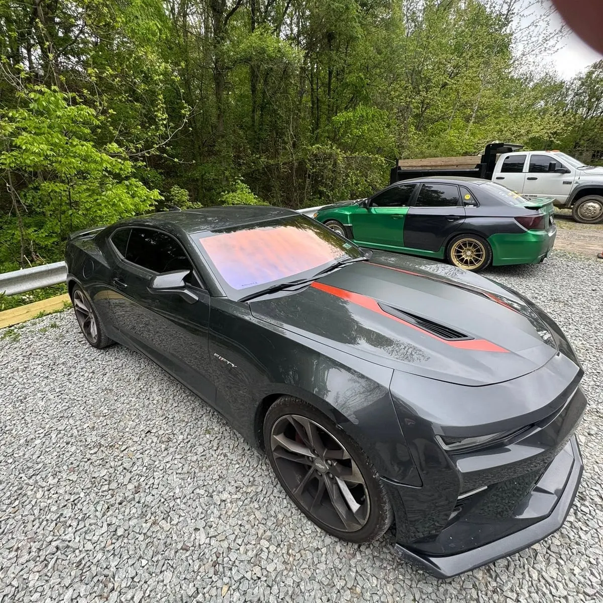 A dark Chevrolet Camaro with tinted glass in the Mr. Tint installation bay