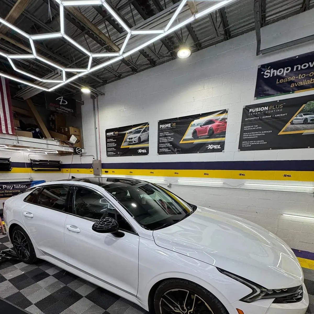 A white Kia K5 in the Mr. Tint installation bay in Plum, Pennsylvania