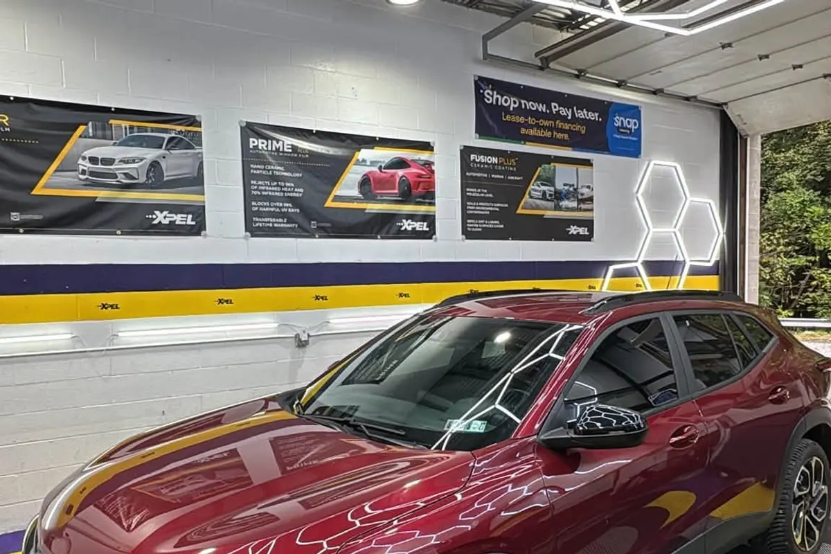 A red Chevrolet SUV inside the Mr. Tint installation bay