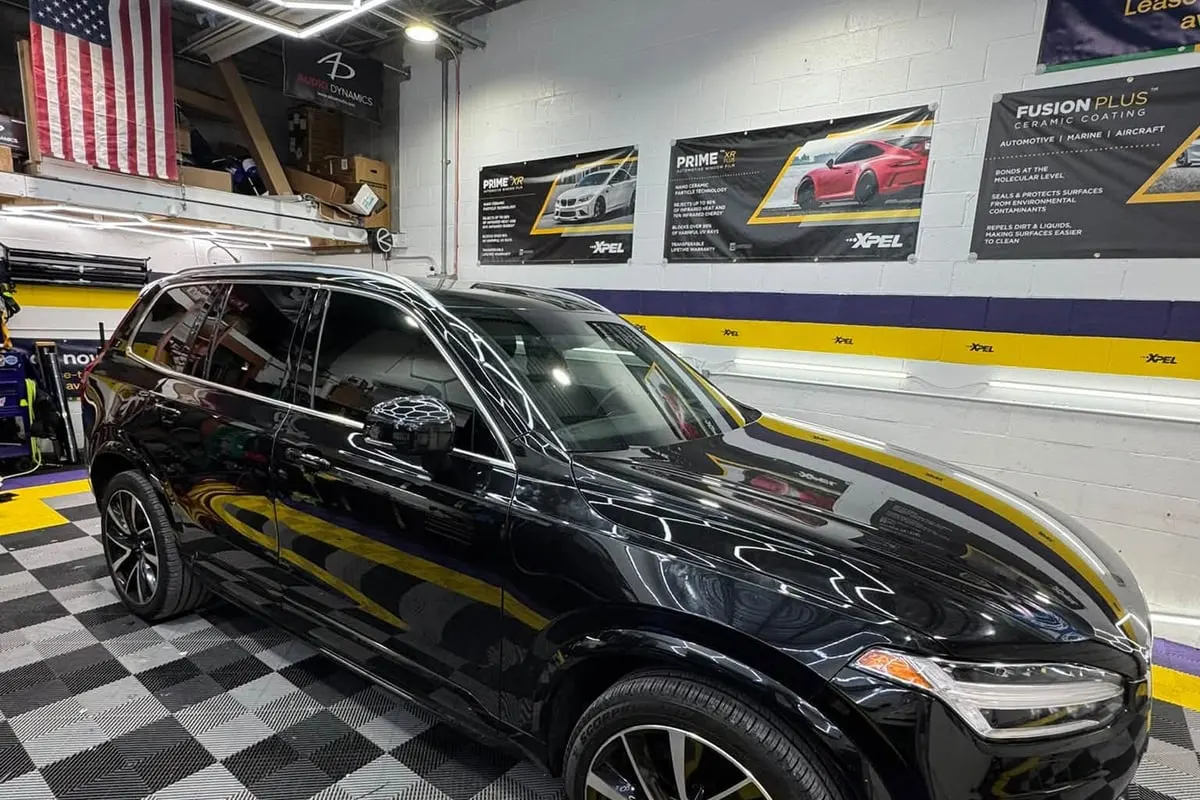A black BMW SUV inside the Mr. Tint installation bay